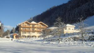 ゴールデックにあるHotel Seeblickの山前雪中大きな建物