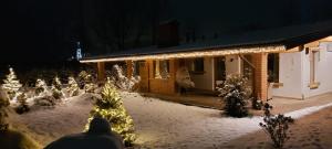 uma casa coberta de luzes de Natal na neve em Thomhof Chalets em Bran