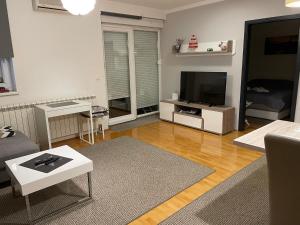 sala de estar con sofá y TV en Apartman Luna near Zagreb Airport, en Velika Gorica