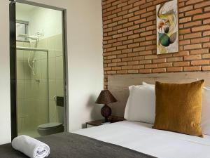 um quarto com uma cama e uma parede de tijolos em B & A Suites Inn Flats - Apart Flat Stratus em Anápolis