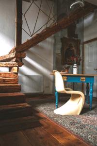 a room with a table and a white chair at The House a la Cluj in Cluj-Napoca