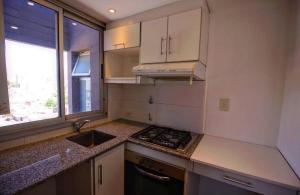 a kitchen with a stove and a sink and a window at Naranjo 9D in San Salvador de Jujuy