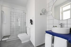 een badkamer met een wastafel, een toilet en een spiegel bij Exe Vigo in Vigo