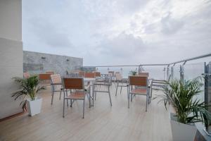 a balcony with a table and chairs and the ocean at Amber Beach Hotel in Hulhumale