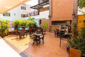 d'une terrasse avec des tables, des chaises et une table. dans l'établissement Hotel Millenium Victoria Plaza, à Cúcuta