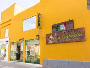 un bâtiment jaune avec un panneau sur son côté dans l'établissement Hotel Millenium Victoria Plaza, à Cúcuta