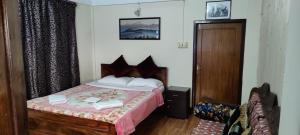 een slaapkamer met een bed en een houten deur bij The River View Homestay in Kurseong