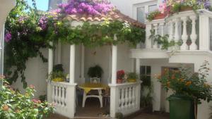 een wit huis met een tafel en bloemen erop bij Apartments Vodice Marica in Vodice