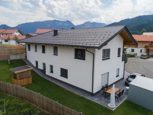 una casa blanca con techo en un patio en Ferienwohnungen Mountainfloor - Chiemgau Karte, en Inzell