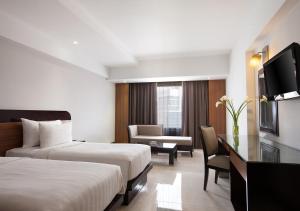 เตียงในห้องที่ Hotel Santika Premiere Semarang