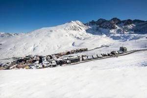 una montaña cubierta de nieve con una ciudad delante de ella en Hotel Camel lot, en Pas de la Casa