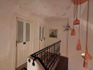 un pasillo con una escalera con una puerta blanca y algunas luces en Pension Föhrenhain, en Gerasdorf bei Wien