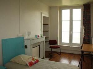 una camera con letto, camino e sedia di Appartement Historique au Centre de Toul, Proche Cathédrale, Tous Services Inclus - FR-1-584-74 a Toul