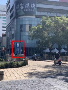 un panneau sur une rue devant un bâtiment dans l'établissement Persimmon Hotel, à Hsinchu