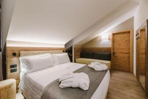 een slaapkamer met 2 handdoeken op een bed bij Chalet Queen in Canazei