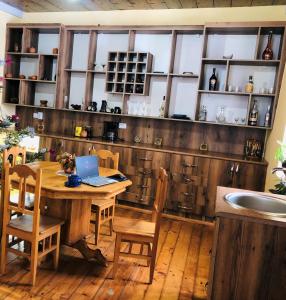 a kitchen with a wooden table with a laptop on it at River side SVANETI in Mestia