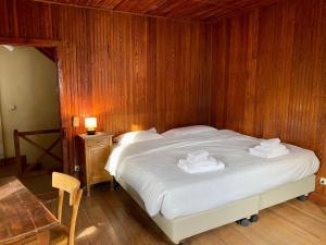 een slaapkamer met een bed met een houten muur bij Chalet Motta in Valtournenche