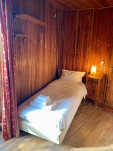 een bed in een kamer met een houten muur bij Chalet Motta in Valtournenche