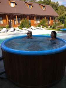 zwei Frauen in einem Whirlpool im Pool in der Unterkunft Karpatska Forel in Swaljawa