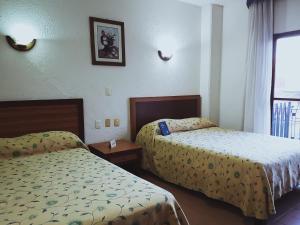 Cette chambre comprend 2 lits et une fenêtre. dans l'établissement Hotel Plaza Independencia, à Villahermosa