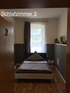 - une petite chambre avec un lit et une fenêtre dans l'établissement Ferienwohnung RIENA, à Riesa