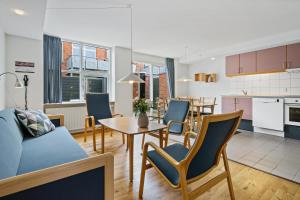 een woonkamer met een tafel en stoelen en een keuken bij Ribe Byferie Resort in Ribe