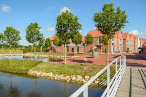 een brug over een rivier voor een gebouw bij Ribe Byferie Resort in Ribe