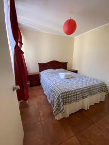 1 dormitorio con 1 cama con manta a cuadros en Departamento Mar, en La Serena