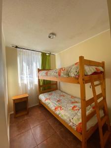 1 dormitorio con 2 literas y ventana en Departamento Mar, en La Serena