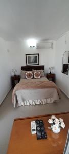 - une chambre avec un lit et 2 télécommandes sur une table dans l'établissement Apartamento Familiar Marta, à Colonia del Sacramento