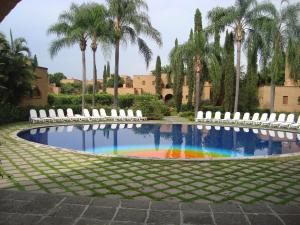 una piscina con sillas y un arco iris en Mision del Sol Resort & Spa Adults Only, en Cuernavaca