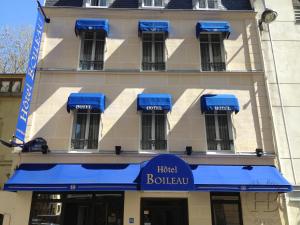 a hotel building with blue awnings in front of it at Hotel Boileau in Paris