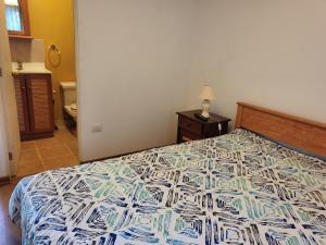 a bedroom with a bed with a colorful bedspread at Casas Isla Negra in El Quisco