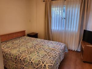 a bedroom with a bed and a large window at Casas Isla Negra in El Quisco