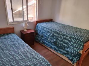 a bedroom with two beds and a window at Casas Isla Negra in El Quisco