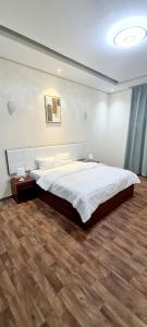 um quarto com uma cama grande e piso em madeira em HAVANA HOLIDAY HOMES MIRDIF no Dubai