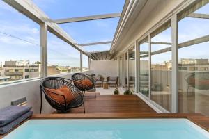 Appartamento dotato di balcone con piscina e sedie. di ACRON suites & apartments ad Atene