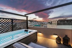 una vasca idromassaggio su un balcone con vista di ACRON suites & apartments ad Atene