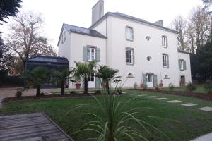 une maison blanche avec un palmier en face dans l'établissement Les Îles Vagabondes, à Saint-Malo