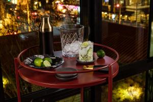 a red table with a wine glass and a plate of olives at  Liz by Black Swan - DC Executive Flat in Washington