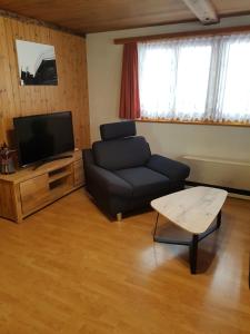 a living room with a couch and a tv at Imseng in Wiler