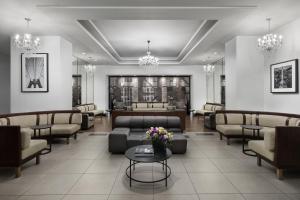 a waiting room with couches and tables and chandeliers at The Manhattan at Times Square in New York