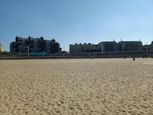 una spiaggia sabbiosa con edifici sullo sfondo di Beach House Rodine - free parking & bikes a Scheveningen