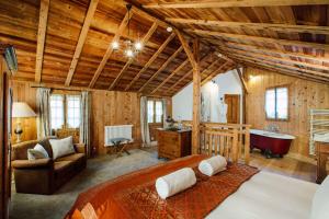 um quarto com uma cama grande e uma banheira em Hotel Mas de la Coutettaz, The Farmhouse em Morzine