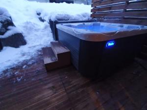 een hot tub met een blauw licht in de sneeuw bij Chalet Delphinette - Spa privatif in Morzine