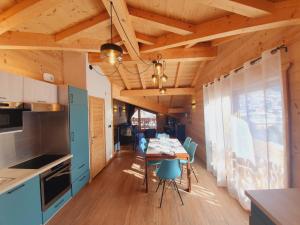 een keuken en eetkamer met een tafel en stoelen bij Chalet Delphinette - Spa privatif in Morzine