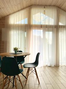 d'une salle à manger avec une table, des chaises et une fenêtre. dans l'établissement Treeskit House, à Horenka