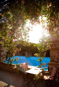 une terrasse avec une table et des chaises en face d'une piscine dans l'établissement Mouzaliko Guesthouse Mansion, à Kambos