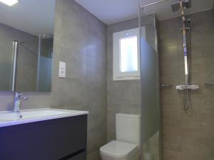 y baño con aseo, lavabo y ducha. en Rentalmar Navarra family suites, en Salou