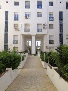 ein weißes Gebäude mit einem Gehweg davor in der Unterkunft Captivating 2-Bed Apartment in Tunis in Tunis